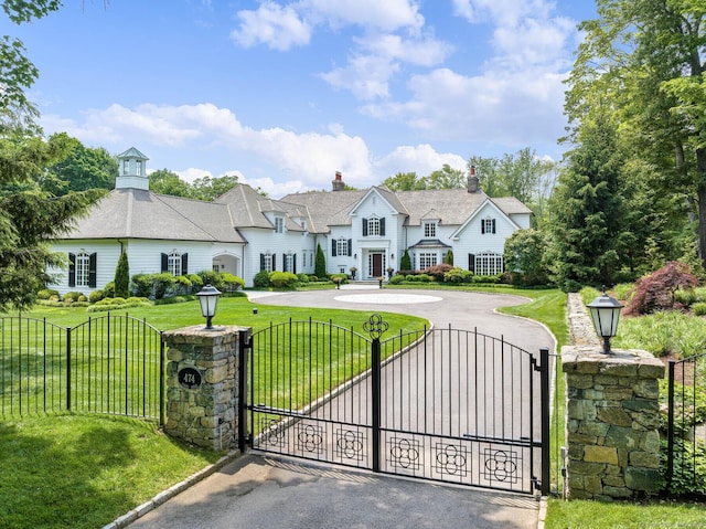474 Ponus Rdg, New Canaan, CT 06840 - view of front facade featuring curved driveway, a gate, and a chimney
