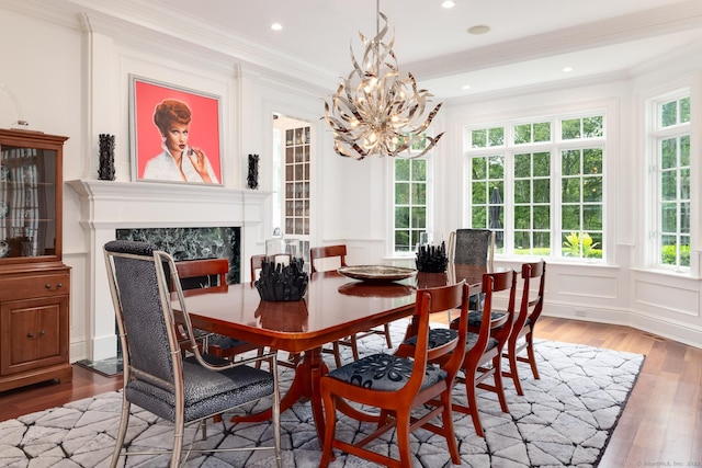 474 Ponus Rdg, New Canaan, CT 06840 - dining space featuring a high end fireplace, light wood finished floors, a decorative wall, a chandelier, and crown molding