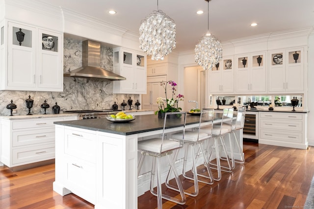 474 Ponus Rdg, New Canaan, CT 06840 - kitchen featuring wall chimney exhaust hood, a chandelier, dark countertops, backsplash, and wood finished floors