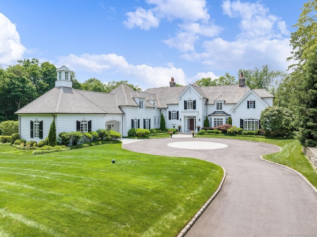 474 Ponus Rdg, New Canaan, CT 06840 - view of front facade with curved driveway, a chimney, and a front yard