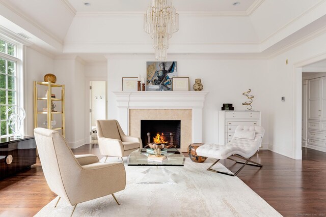 474 Ponus Rdg, New Canaan, CT 06840 - living area featuring a raised ceiling, wood finished floors, a chandelier, a fireplace, and ornamental molding
