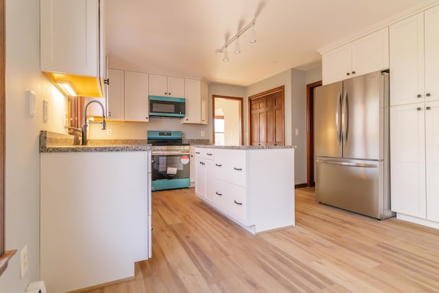 155 Melinda Ln, Bristol, CT 06010 - kitchen with appliances with stainless steel finishes, white cabinets, light wood finished floors, a kitchen island, and track lighting