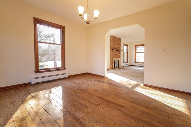 155 Melinda Ln, Bristol, CT 06010 - spare room featuring a baseboard radiator, hardwood / wood-style floors, plenty of natural light, and arched walkways