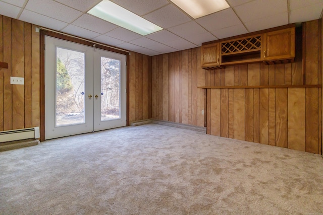 155 Melinda Ln, Bristol, CT 06010 - carpeted spare room featuring a baseboard heating unit, a paneled ceiling, french doors, and wood walls