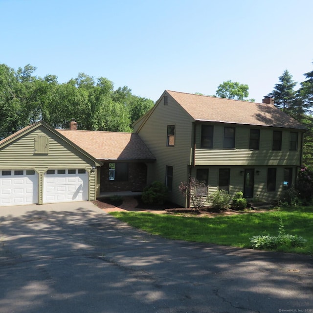 155 Melinda Ln, Bristol, CT 06010 - colonial home with a chimney, asphalt driveway, an attached garage, and roof with shingles