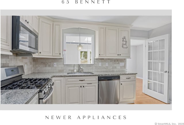 65 Bennett St, Fairfield, CT 06825 - kitchen with appliances with stainless steel finishes, tasteful backsplash, light wood-style floors, hanging light fixtures, and light stone countertops