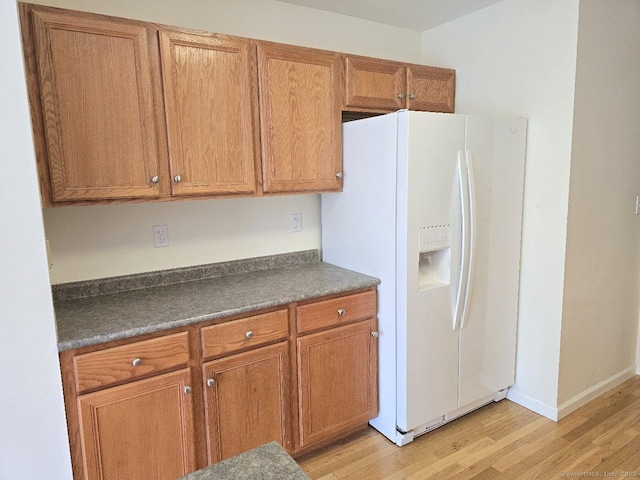 244 Oakland St Apt F, Manchester, CT 06042 - kitchen with white fridge with ice dispenser, dark countertops, light wood-type flooring, and brown cabinets