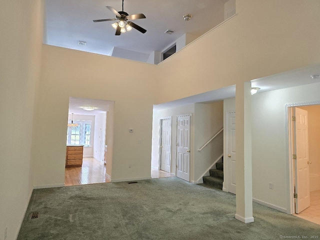 244 Oakland St Apt F, Manchester, CT 06042 - unfurnished living room featuring carpet, stairs, ceiling fan, and a towering ceiling