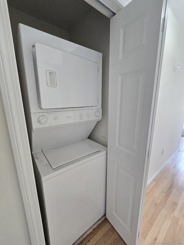 244 Oakland St Apt F, Manchester, CT 06042 - washroom featuring stacked washing machine and dryer and light wood-style floors
