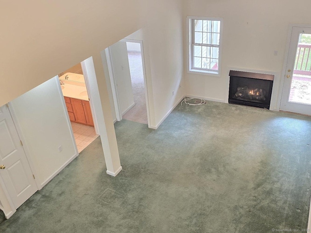 244 Oakland St Apt F, Manchester, CT 06042 - unfurnished living room with carpet floors, plenty of natural light, and a lit fireplace