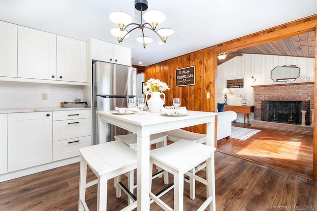 5 Lake Pt, Haddam, CT 06441 - kitchen featuring freestanding refrigerator, a chandelier, dark wood-type flooring, decorative backsplash, and wooden walls