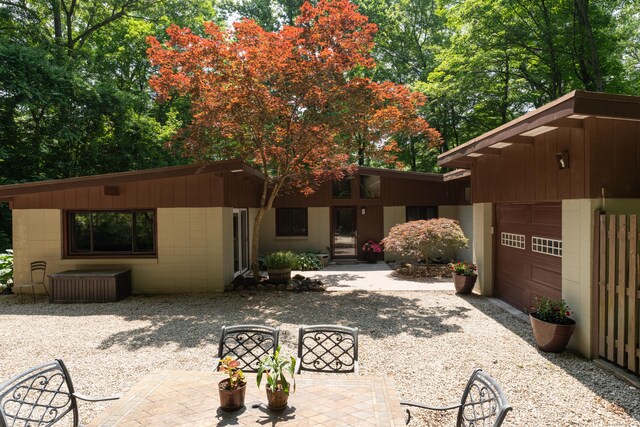 120 Highwoods Dr, Guilford, CT 06437 - view of front facade featuring a garage, concrete block siding, and gravel driveway