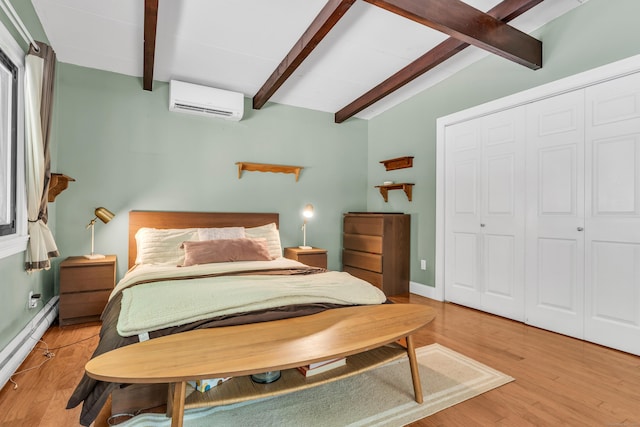 120 Highwoods Dr, Guilford, CT 06437 - bedroom with an AC wall unit, baseboard heating, light wood-style flooring, and a closet