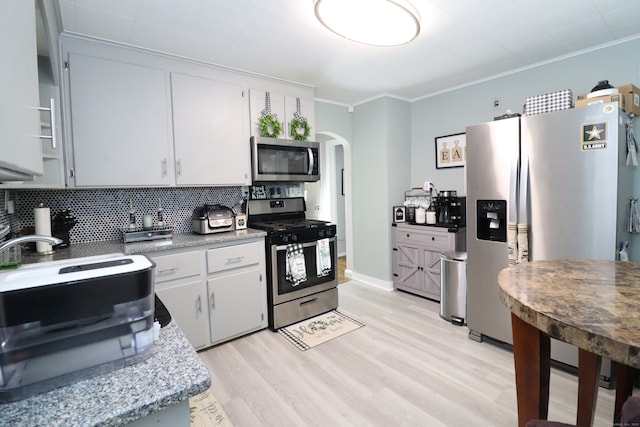 80 Longbranch Ave, Stratford, CT 06615 - kitchen with stainless steel appliances, arched walkways, ornamental molding, tasteful backsplash, and light wood-style flooring