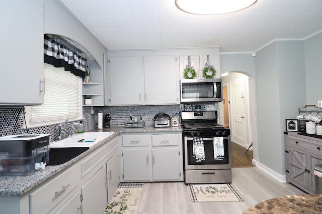 80 Longbranch Ave, Stratford, CT 06615 - kitchen featuring appliances with stainless steel finishes, arched walkways, open shelves, backsplash, and crown molding