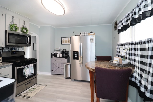 80 Longbranch Ave, Stratford, CT 06615 - kitchen with stainless steel appliances, crown molding, arched walkways, and light wood-style flooring