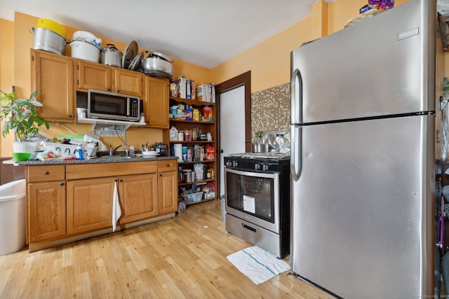 83 James St, New Haven, CT 06513 - kitchen featuring appliances with stainless steel finishes, light wood-type flooring, open shelves, brown cabinetry, and dark countertops