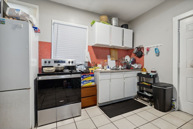 83 James St, New Haven, CT 06513 - kitchen with electric stove, freestanding refrigerator, light tile patterned flooring, white cabinetry, and light countertops
