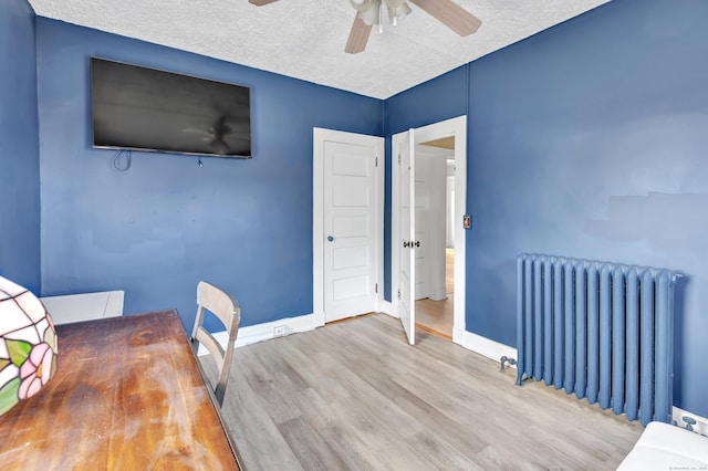 819 Connecticut Ave Unit 6, Bridgeport, CT 06607 - unfurnished bedroom with radiator heating unit, wood finished floors, a textured ceiling, and a ceiling fan