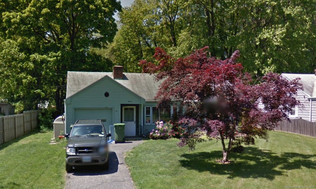 view of front of property with a garage, asphalt driveway, and a chimney