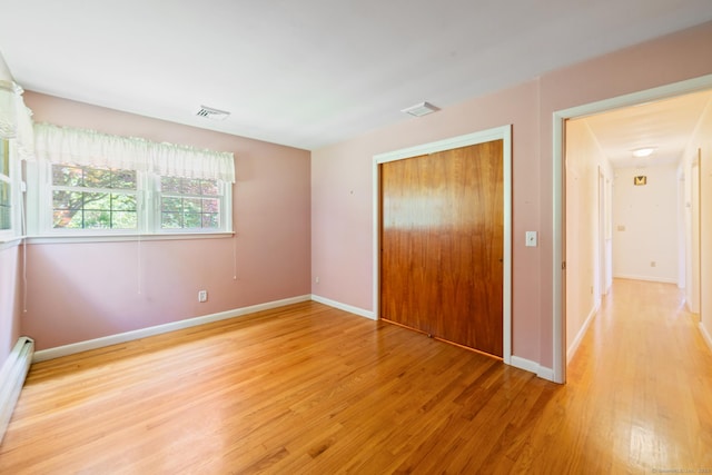 765 Kettletown Rd, Southbury, CT 06488 - unfurnished bedroom featuring light wood-style floors, a closet, and a baseboard radiator