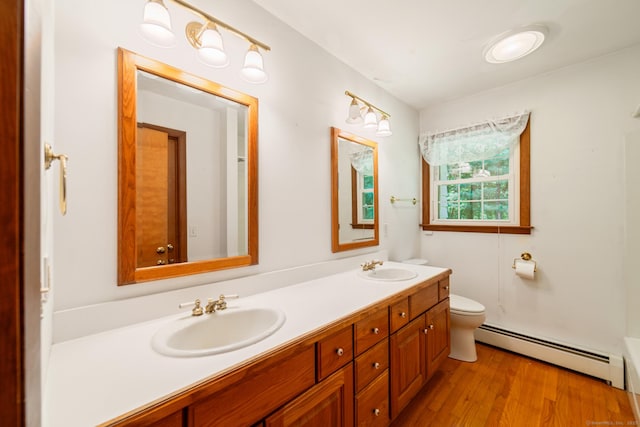 765 Kettletown Rd, Southbury, CT 06488 - full bathroom with baseboard heating, double vanity, wood finished floors, and a tub to relax in