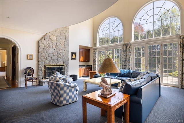 21 Queens Grant Dr, Fairfield, CT 06824 - living room with carpet, a high ceiling, arched walkways, a fireplace, and ornamental molding