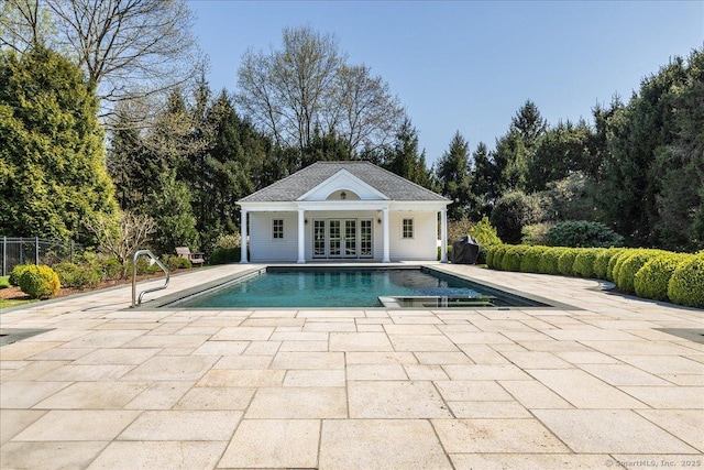 21 Queens Grant Dr, Fairfield, CT 06824 - outdoor pool with a patio area, view of wooded area, an outbuilding, french doors, and an exterior structure