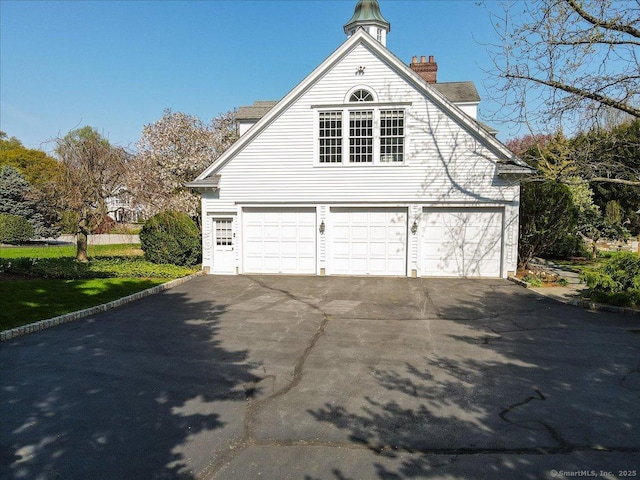 21 Queens Grant Dr, Fairfield, CT 06824 - view of home's exterior with a chimney and a garage