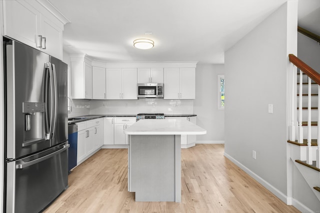 440 Lakeview Dr, Suffield, CT 06093 - kitchen with appliances with stainless steel finishes, backsplash, white cabinetry, and light wood-type flooring
