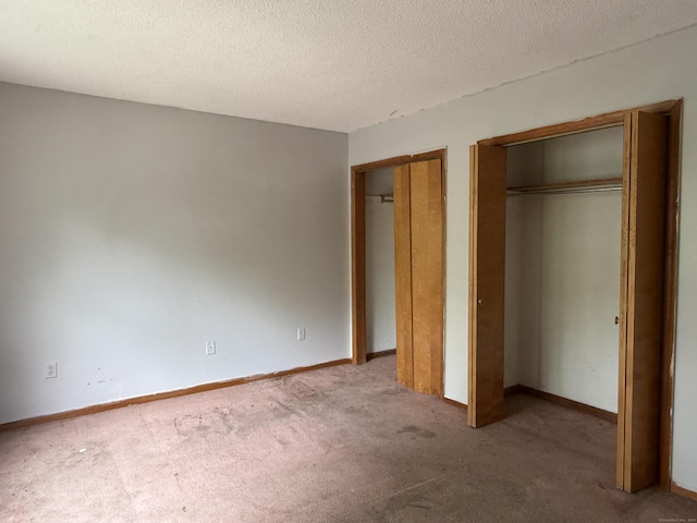 122 Clark St Unit B, Hartford, CT 06120 - unfurnished bedroom featuring two closets, carpet flooring, and a textured ceiling
