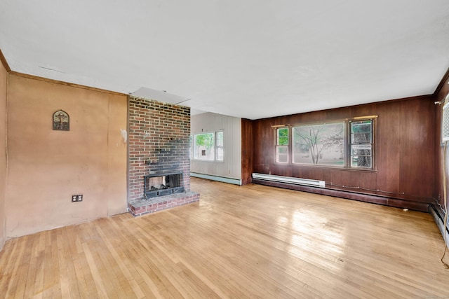 134 Sunset St, Windsor Locks, CT 06096 - unfurnished living room with baseboard heating, wood-type flooring, a brick fireplace, and wooden walls