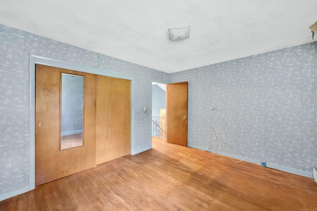 134 Sunset St, Windsor Locks, CT 06096 - unfurnished bedroom featuring wallpapered walls, wood finished floors, and a closet