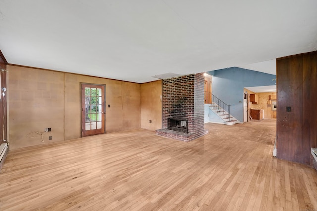134 Sunset St, Windsor Locks, CT 06096 - unfurnished living room with light wood-type flooring, a fireplace, stairway, and wooden walls