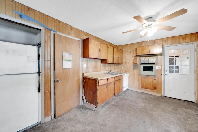 134 Sunset St, Windsor Locks, CT 06096 - kitchen with white appliances, wood walls, light countertops, a ceiling fan, and brown cabinetry