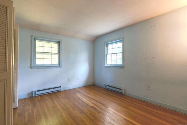 22 Trumbull Rd, Waterford, CT 06385 - unfurnished room with a baseboard radiator, hardwood / wood-style floors, lofted ceiling, and a textured ceiling