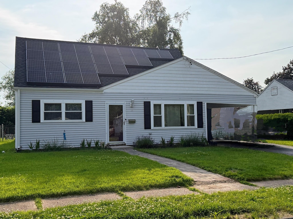 15 Britt Rd, East Hartford, CT 06118 - view of front facade with solar panels, entry steps, a front lawn, and roof with shingles
