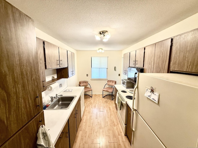 32 Heritage Vlg Unit C, Southbury, CT 06488 - kitchen with white appliances, light wood-type flooring, light countertops, and a textured ceiling