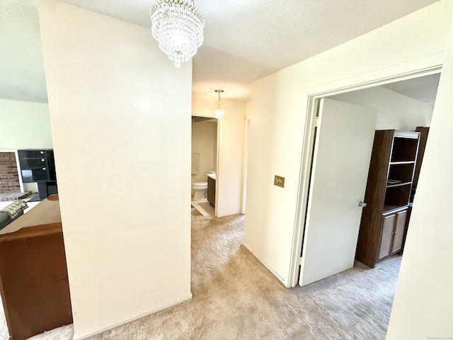 32 Heritage Vlg Unit C, Southbury, CT 06488 - hallway with carpet flooring, a chandelier, and a textured ceiling