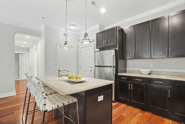 142 E Ave Unit A106, Norwalk, CT 06851 - kitchen with freestanding refrigerator, light wood-style floors, a breakfast bar, light stone countertops, and ornamental molding
