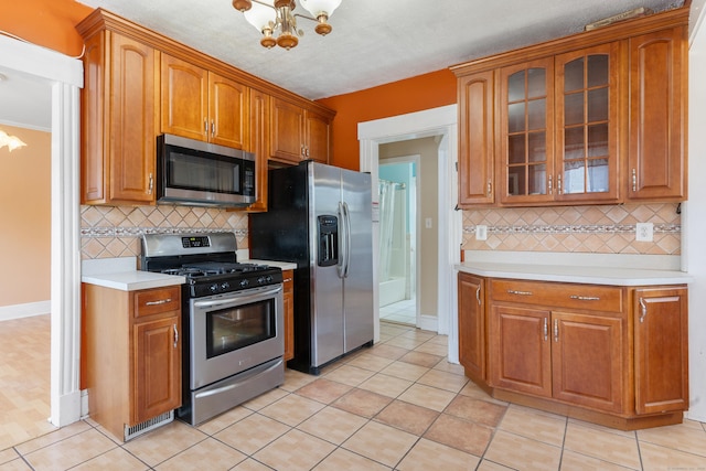 29 Bristol St, West Haven, CT 06516 - kitchen featuring appliances with stainless steel finishes, a chandelier, light countertops, and glass insert cabinets