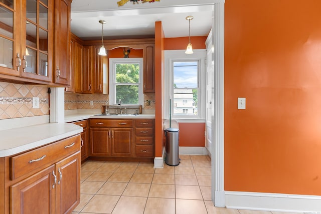 29 Bristol St, West Haven, CT 06516 - kitchen featuring backsplash, light countertops, decorative light fixtures, brown cabinetry, and light tile patterned floors