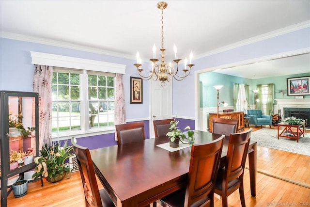156 Killian Ave, Trumbull, CT 06611 - dining space featuring a chandelier, light wood finished floors, crown molding, and a premium fireplace
