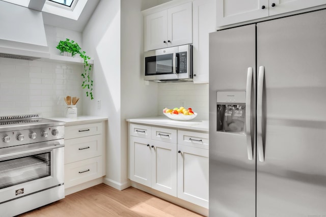 916 N Farms Rd, Wallingford, CT 06492 - kitchen featuring appliances with stainless steel finishes, premium range hood, tasteful backsplash, and a skylight