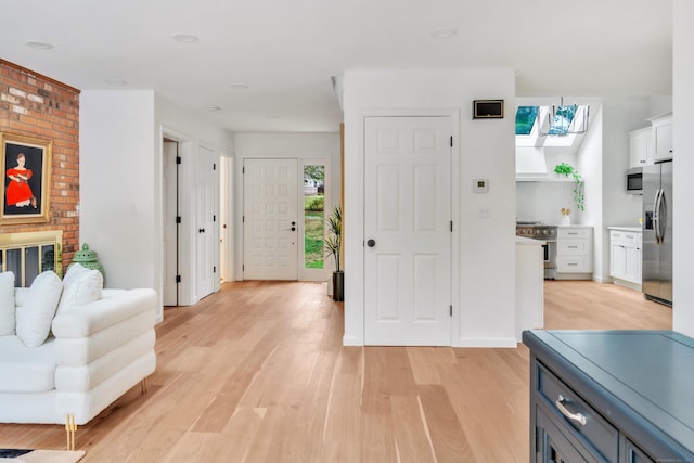 916 N Farms Rd, Wallingford, CT 06492 - kitchen featuring appliances with stainless steel finishes, light wood finished floors, white cabinets, and a skylight