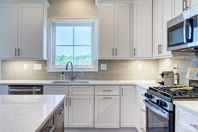 48 Park Ave Unit 48, Stonington, CT 06355 - kitchen featuring appliances with stainless steel finishes, backsplash, white cabinetry, and light stone counters