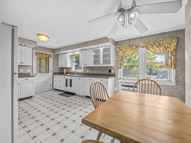 55 Oxbow Dr, Meriden, CT 06450 - kitchen with white cabinets, dark countertops, a ceiling fan, dishwasher, and fridge