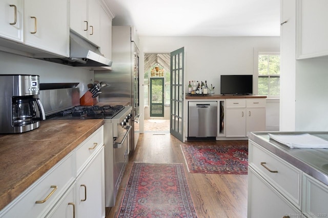 163 Dublin Rd, Canaan, CT 06031 - kitchen featuring appliances with stainless steel finishes, wood finished floors, wooden counters, white cabinets, and under cabinet range hood