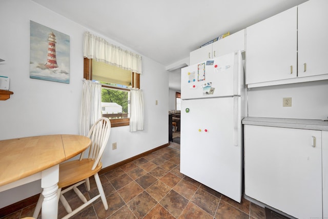 136 Reynolds Bridge Rd, Thomaston, CT 06787 - kitchen featuring freestanding refrigerator, dark stone finish floors, and white cabinets