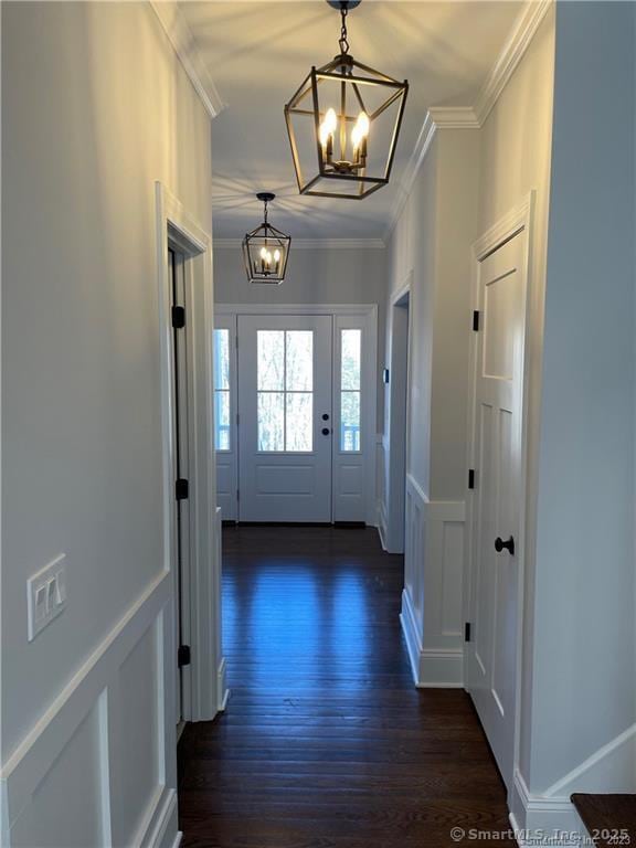 42 Long River Rd, Sherman, CT 06784 - entryway with a chandelier, ornamental molding, dark wood finished floors, a decorative wall, and a wainscoted wall